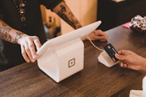 person holding white POS machine