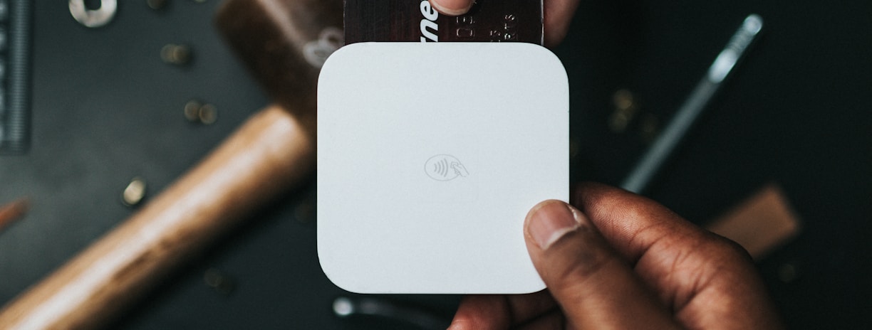 person holding Visa card and white device