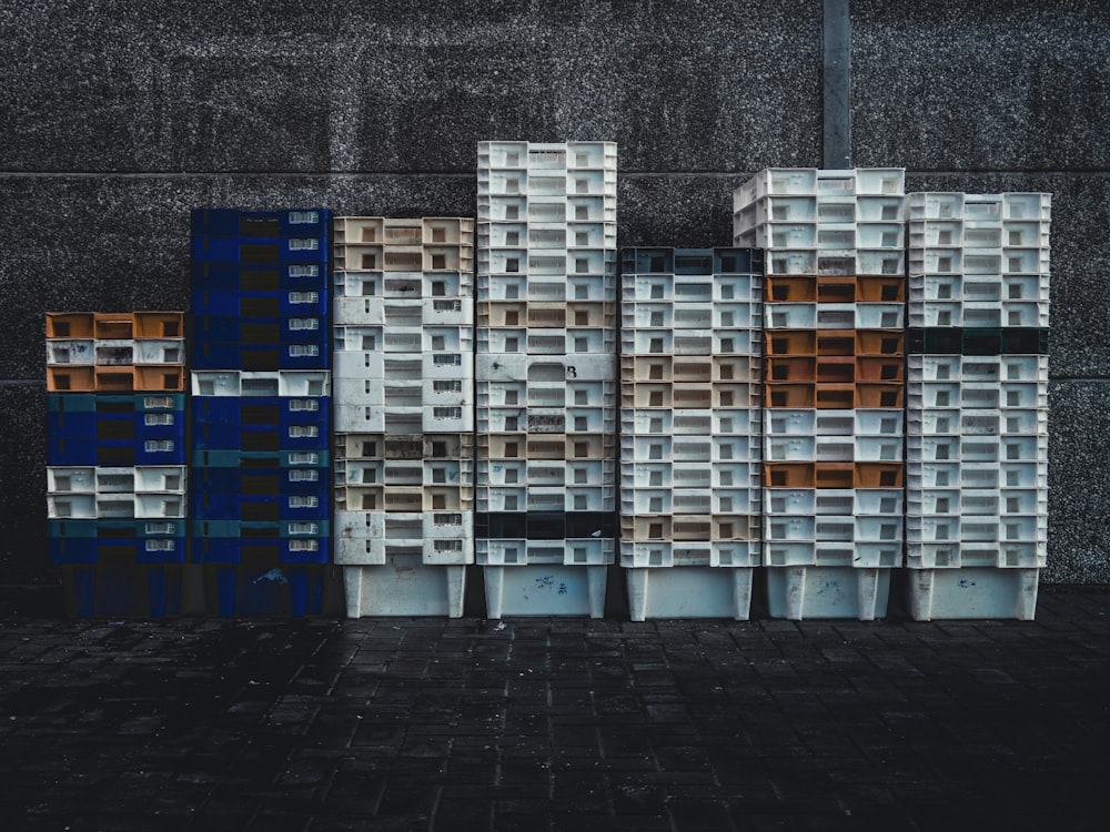 stacked blue, orange, and white plastic crates
