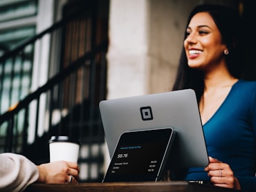 Woman smiling behind silver POS monitor