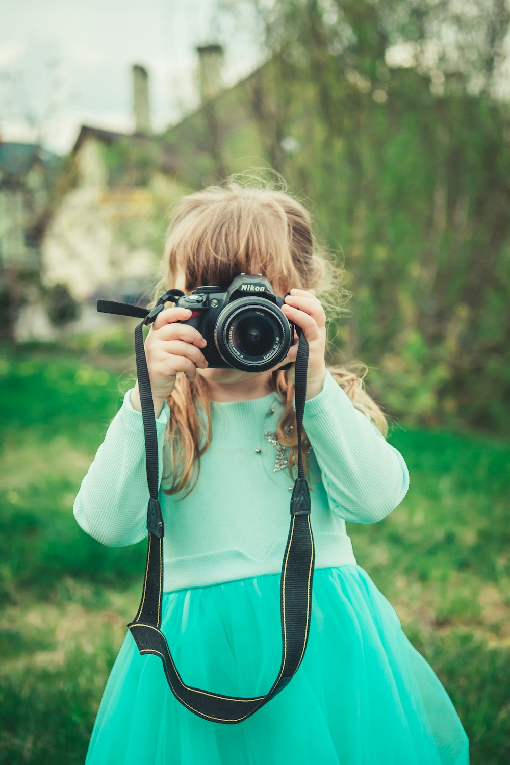 girl holding black DSLR