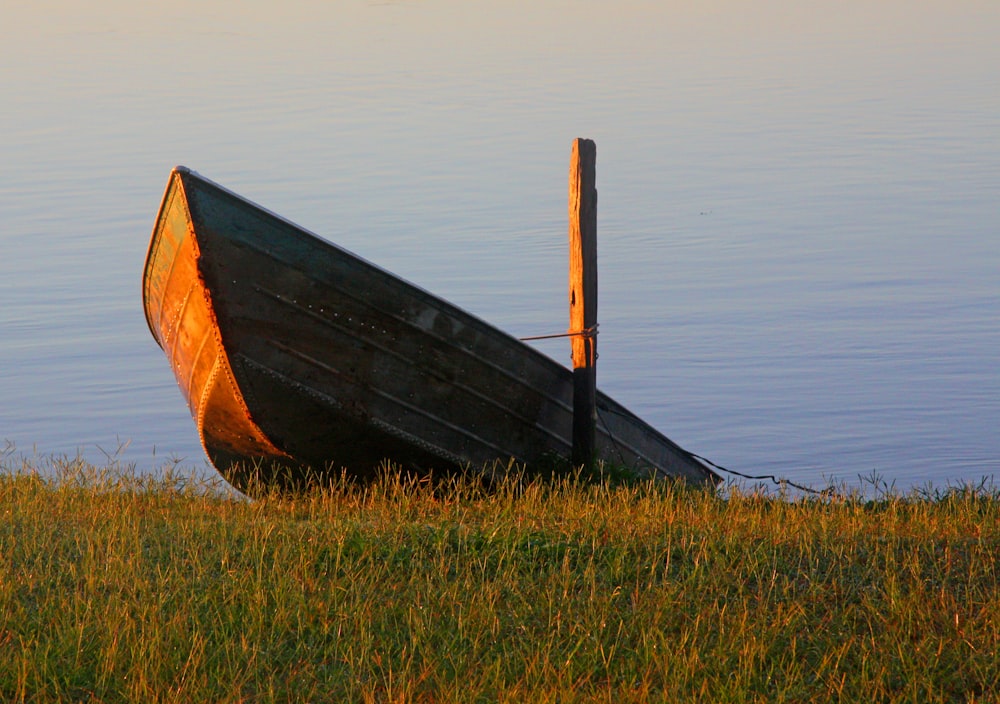 brown wooden boat on green grass field during daytime