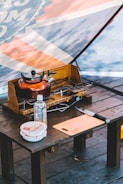 Close-up of camping gear and survival food on a wooden table.