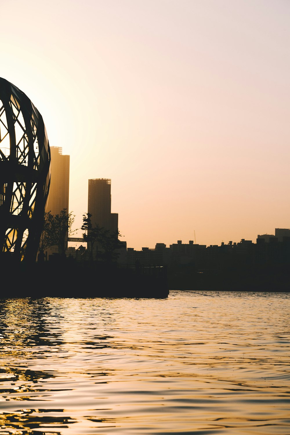 the sun is setting over a city and a body of water