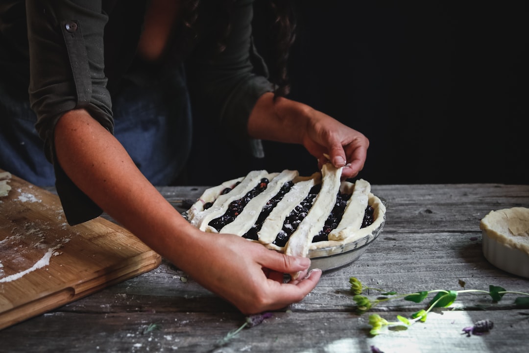 person baking pie on wooden surface