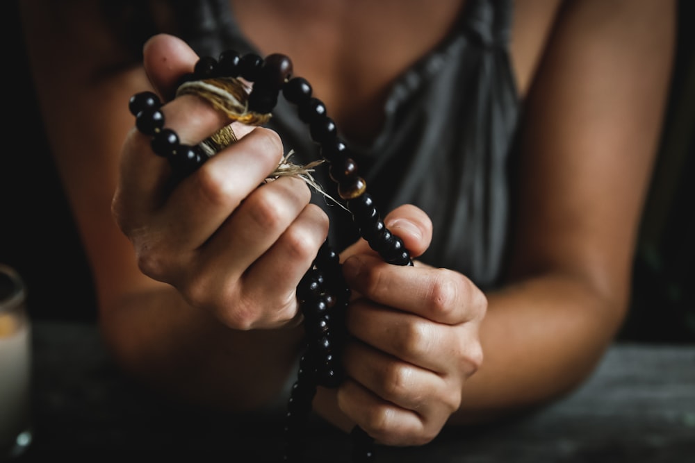 mujer sosteniendo cuentas de oración