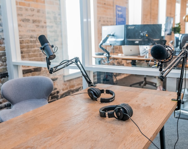 two black headphones on brown wooden table