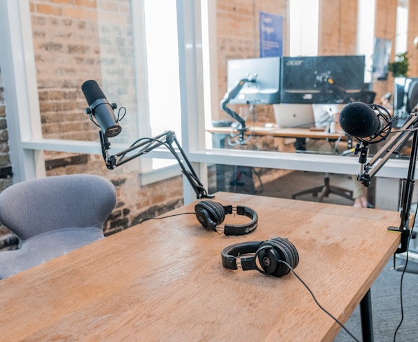 two black headphones on brown wooden table