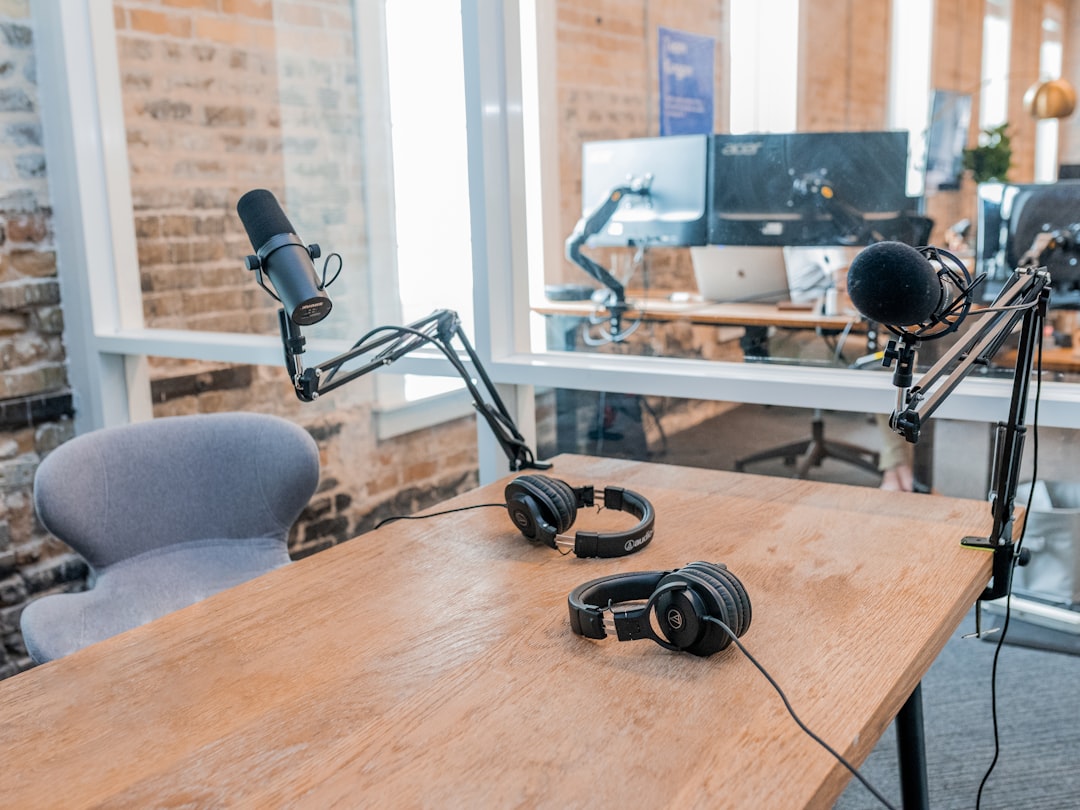  two black headphones on brown wooden table radio