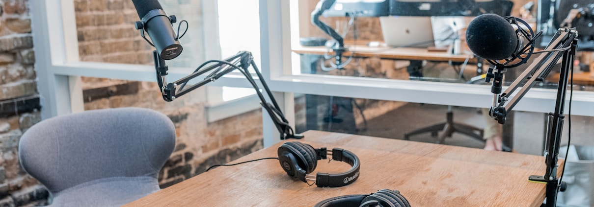 two black headphones on brown wooden table