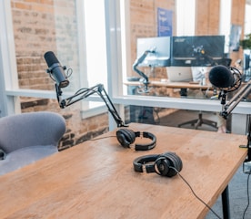 two black headphones on brown wooden table