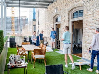 men playing cornhole boards