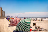 Colorful beach umbrellas set up along the shoreline.