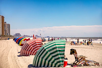 Colorful beach umbrellas set up along the shoreline.