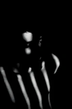 A shadowy, minimalist portrait capturing deep emotion through light and darkness.
