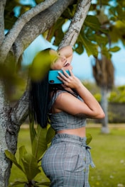 woman listing on to blue smartphone