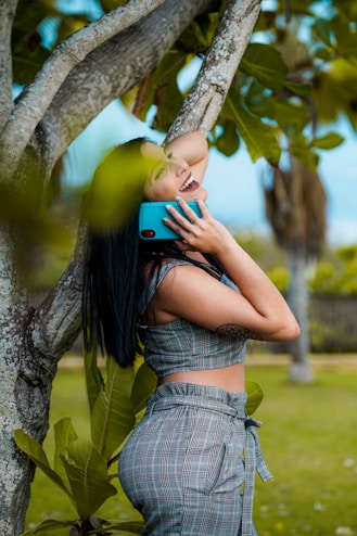 woman listing on to blue smartphone