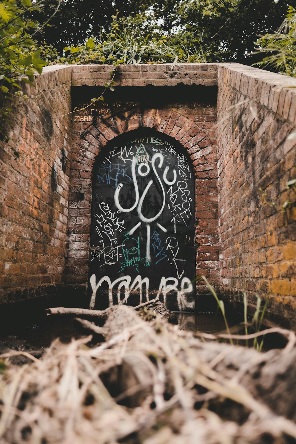 a brick wall with graffiti on it and a door
