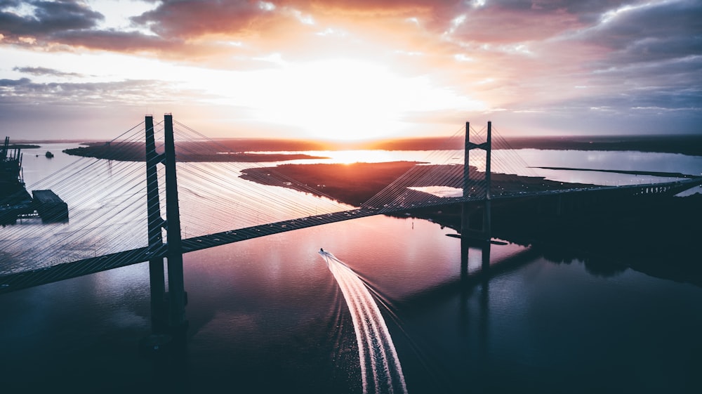 silhouette of ship traveling during sunset