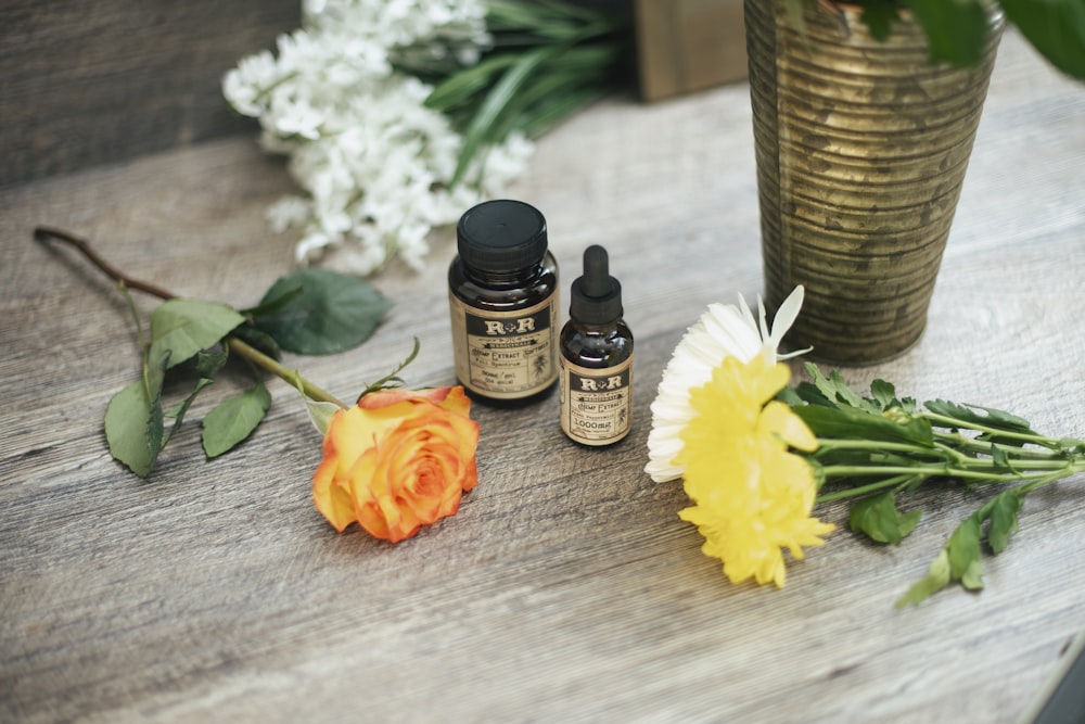 yellow rose flower and two assorted-color petaled flowers