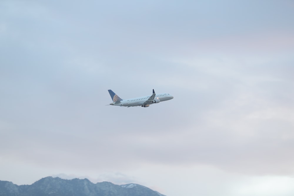 white airliner under white clouds