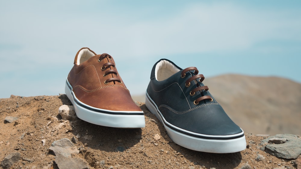 two unpaired brown and blue leather low-top sneakers