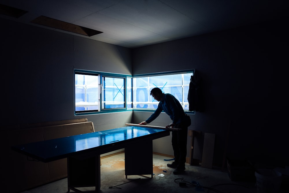 silhouette photography of man inside dim-lighted room