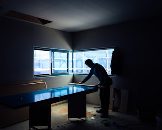 silhouette photography of man inside dim-lighted room