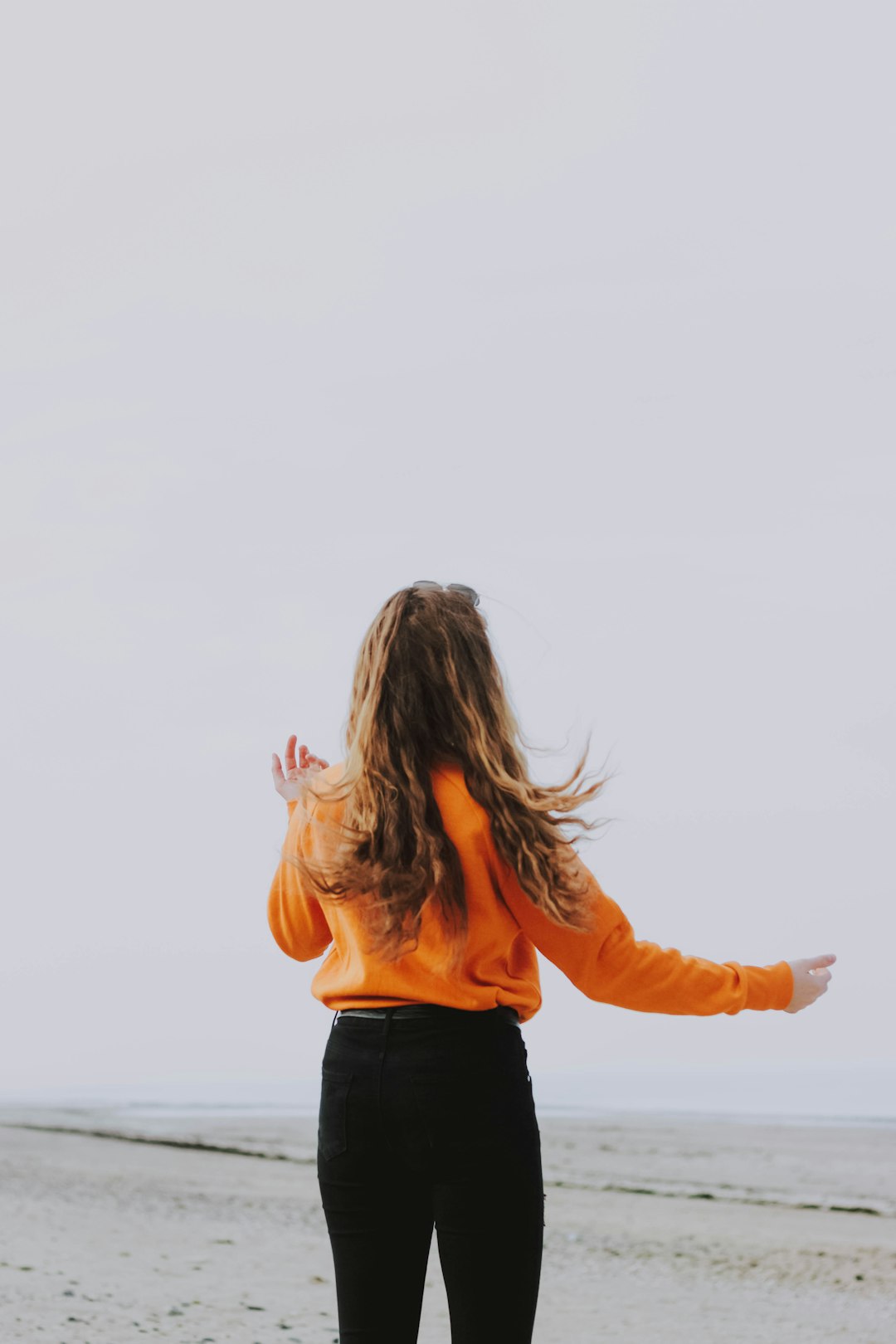 woman in orange jacket and black jeans