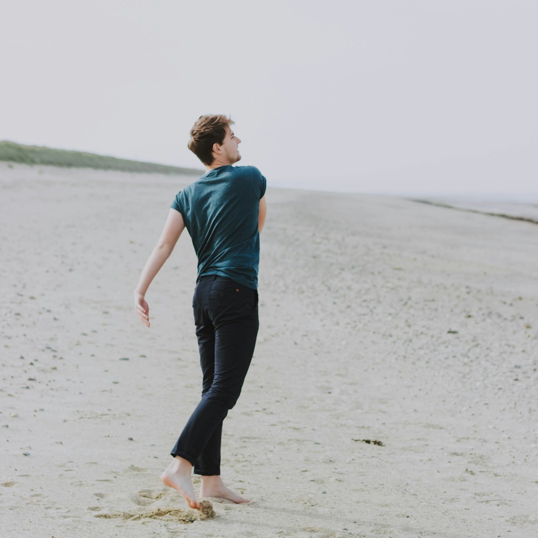 man standing on sand during daytime