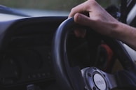 Close-up of a learner’s hands gripping the steering wheel during a lesson on a quiet city road.