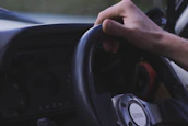 Close-up of hands on a steering wheel with a Diamond Transport logo visible on the dashboard.