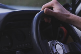 A close-up of a driver's hands on the steering wheel.
