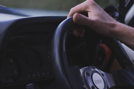 Close-up of hands on a steering wheel with a Diamond Transport logo visible on the dashboard.