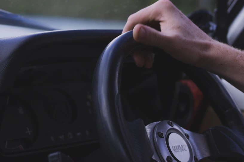 Close-up of a learner gripping a car steering wheel during a driving lesson in Aracaju.