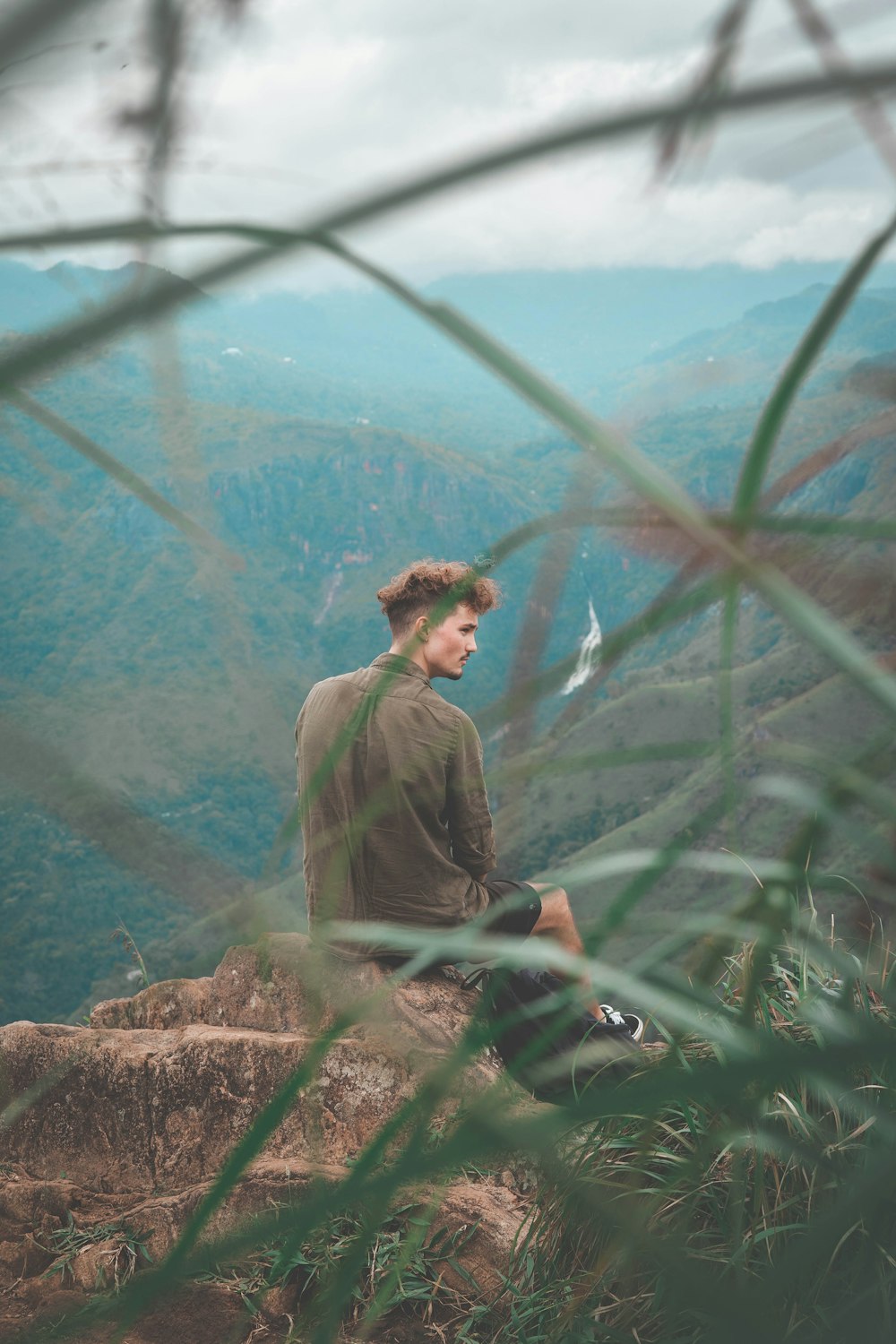 homme assis au sommet d’une montagne