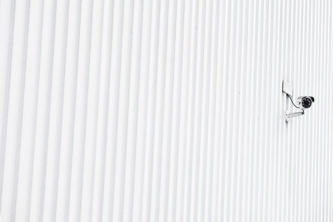 A close-up of a modern security camera mounted on a wall.