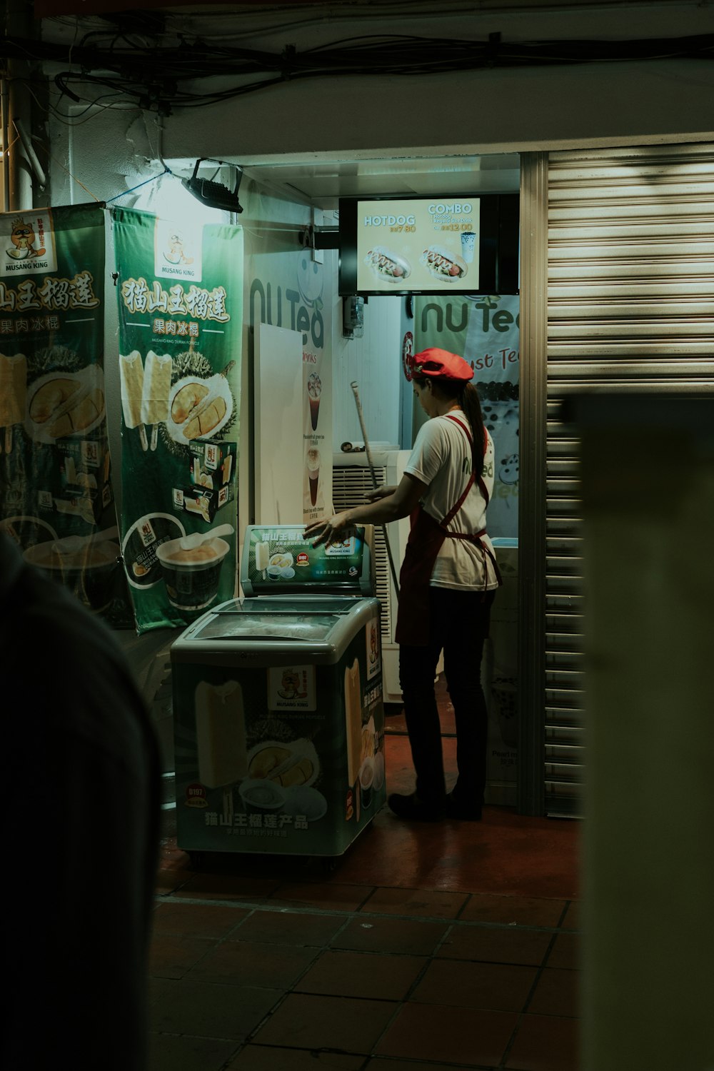 woman wearing white crew-neck shirt and black apron holding white plastic crate