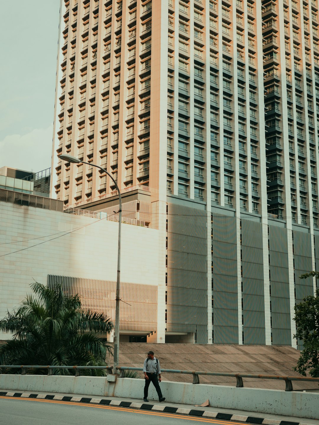 man walking on a concrete bridge in the city