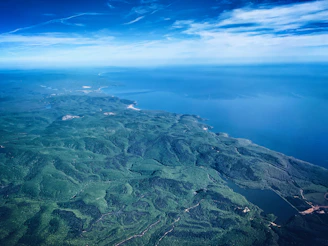 A satellite view of Earth highlighting lush green forests and deep blue oceans under a clear sky.