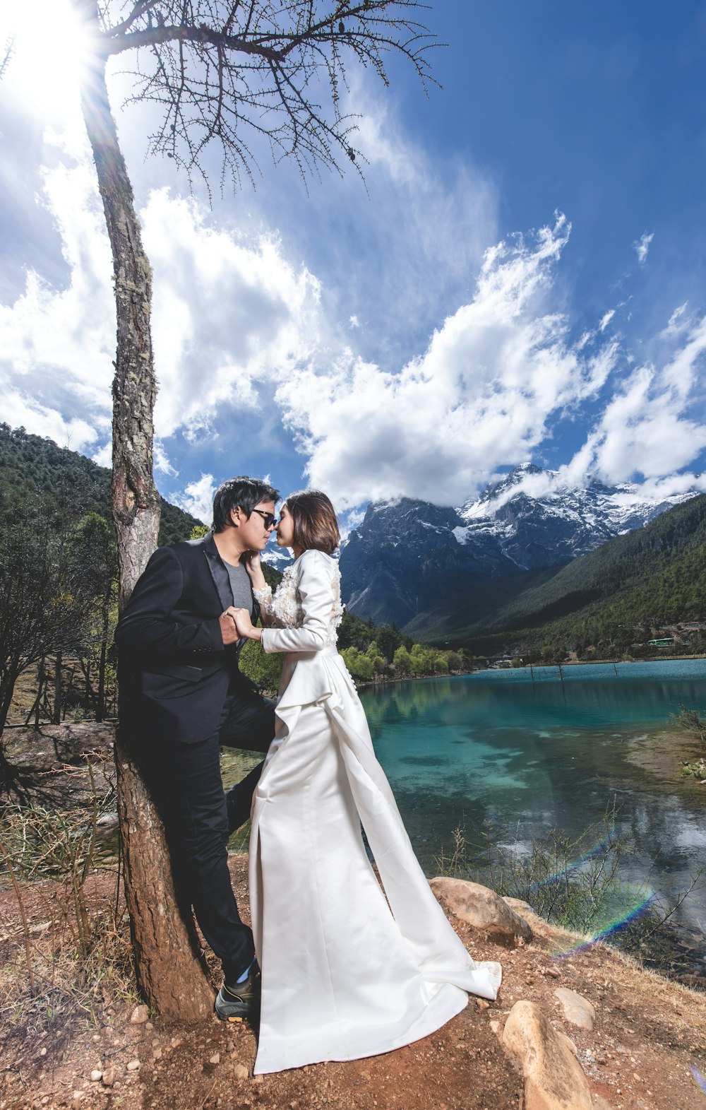 man and woman standing beside tree