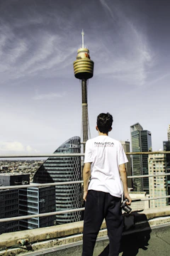 A close-up of a reporter holding a microphone with a city skyline behind.