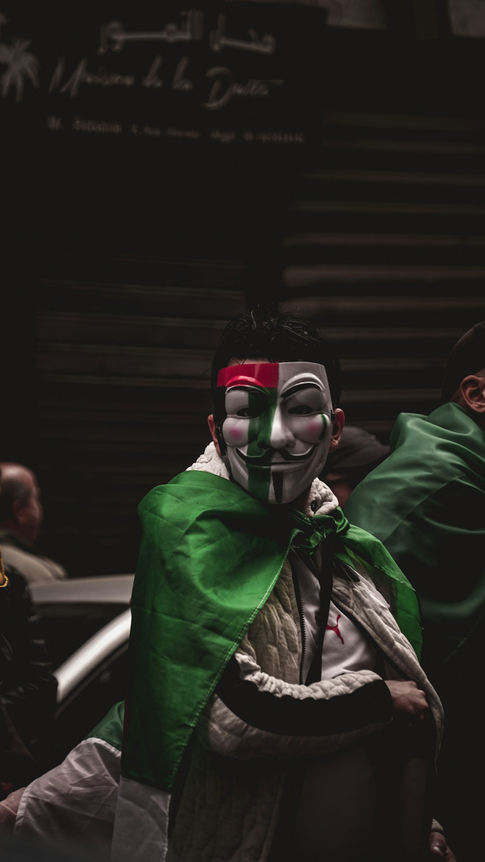 man with Guy Fawkes mask and green cape