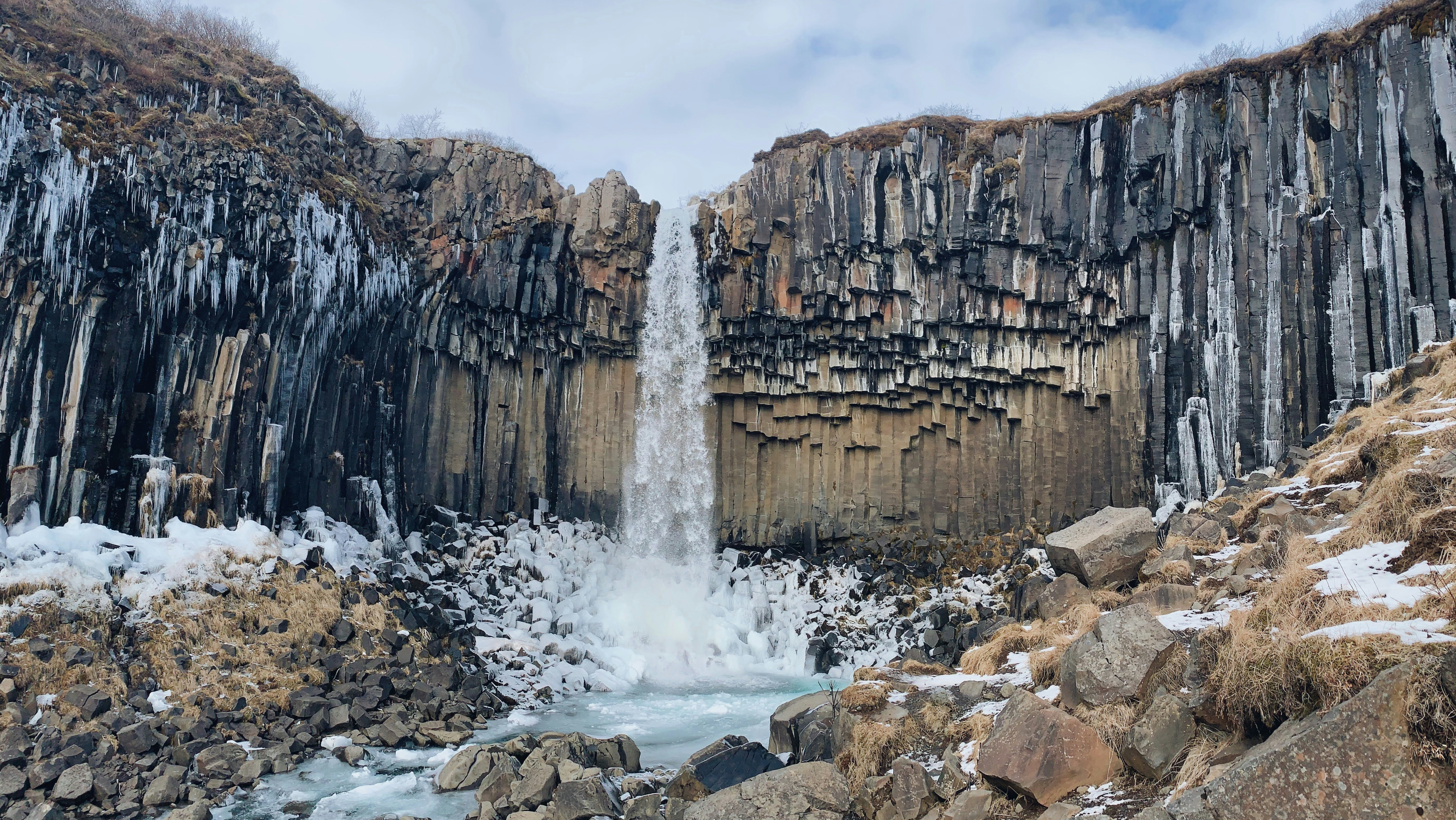 waterfalls under white clouds