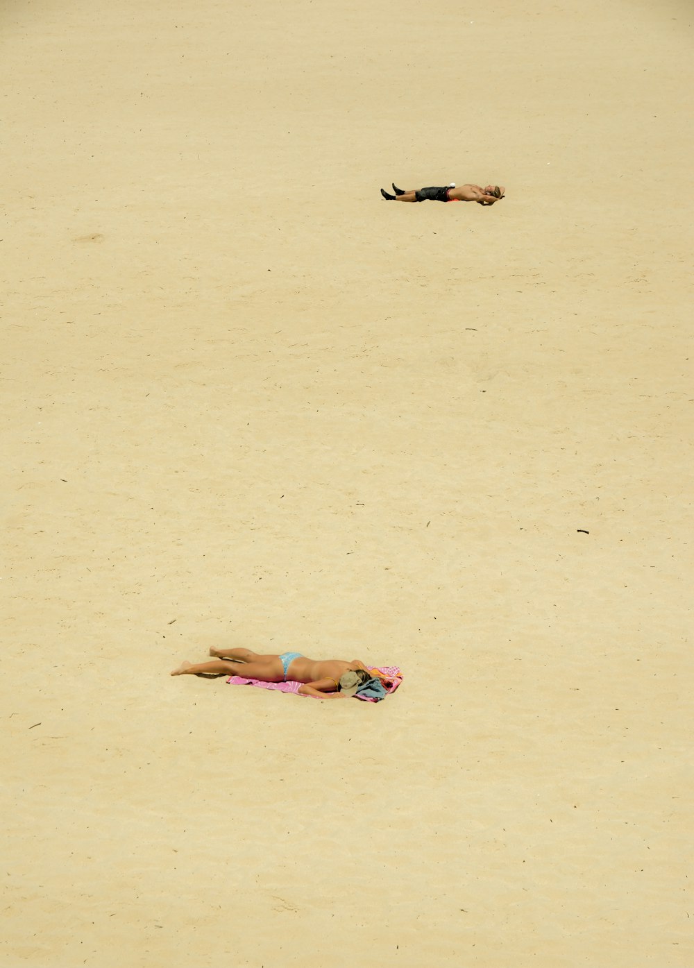 une personne allongée sur une plage avec une planche de surf