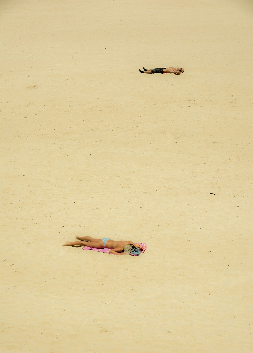 Una persona acostada en una playa con una tabla de surf