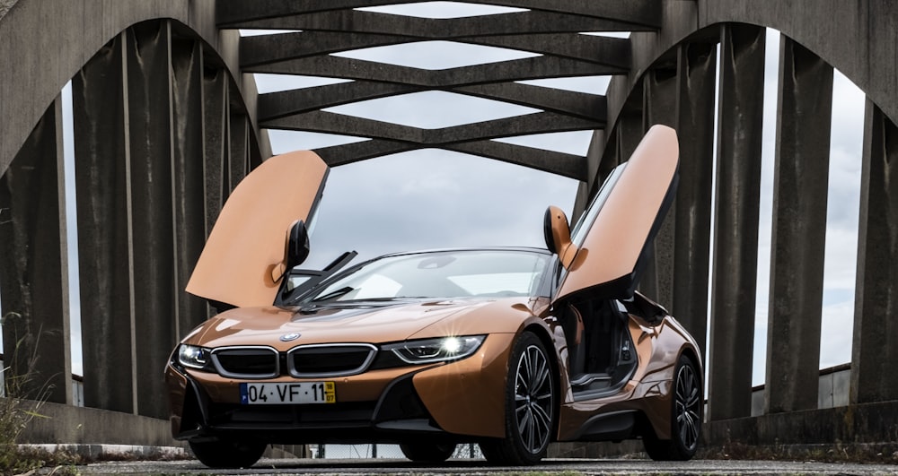 orange BMW i8 parked in middle of bridge