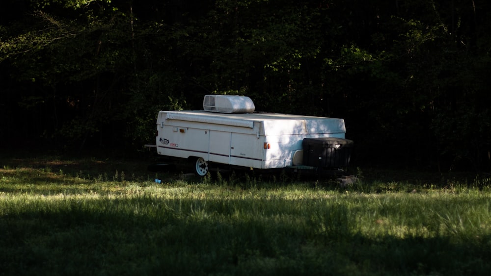 white pop-out camper trailer on grass