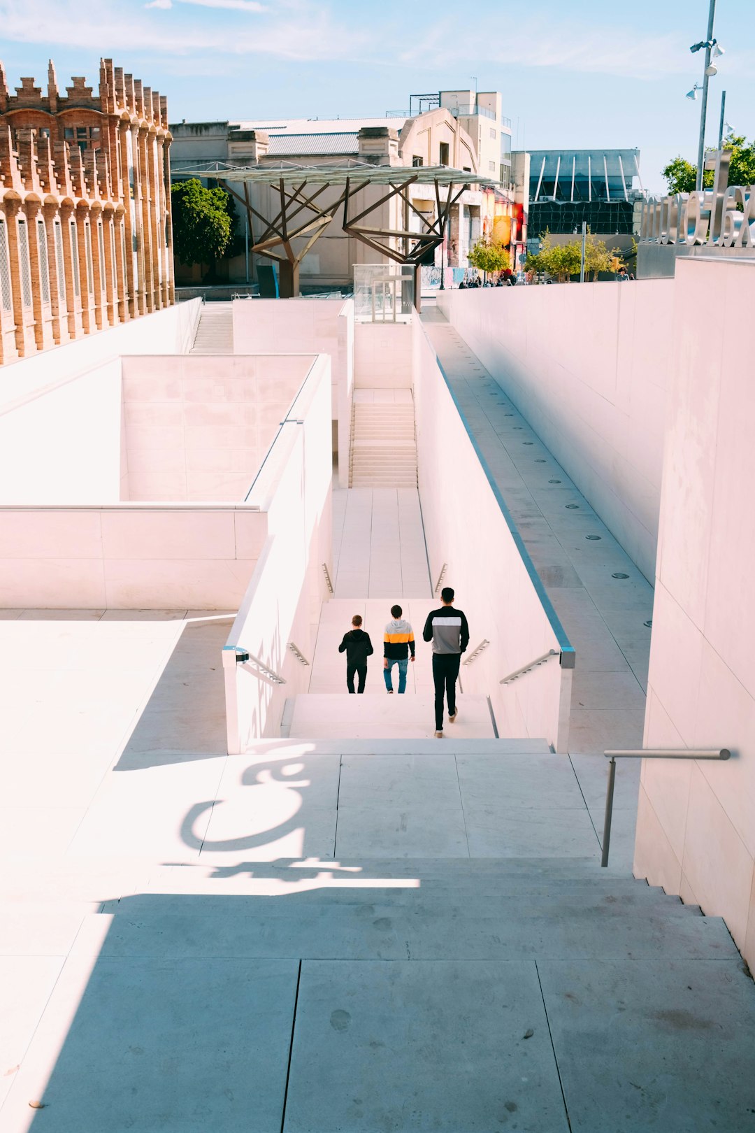 three men going down white stairs