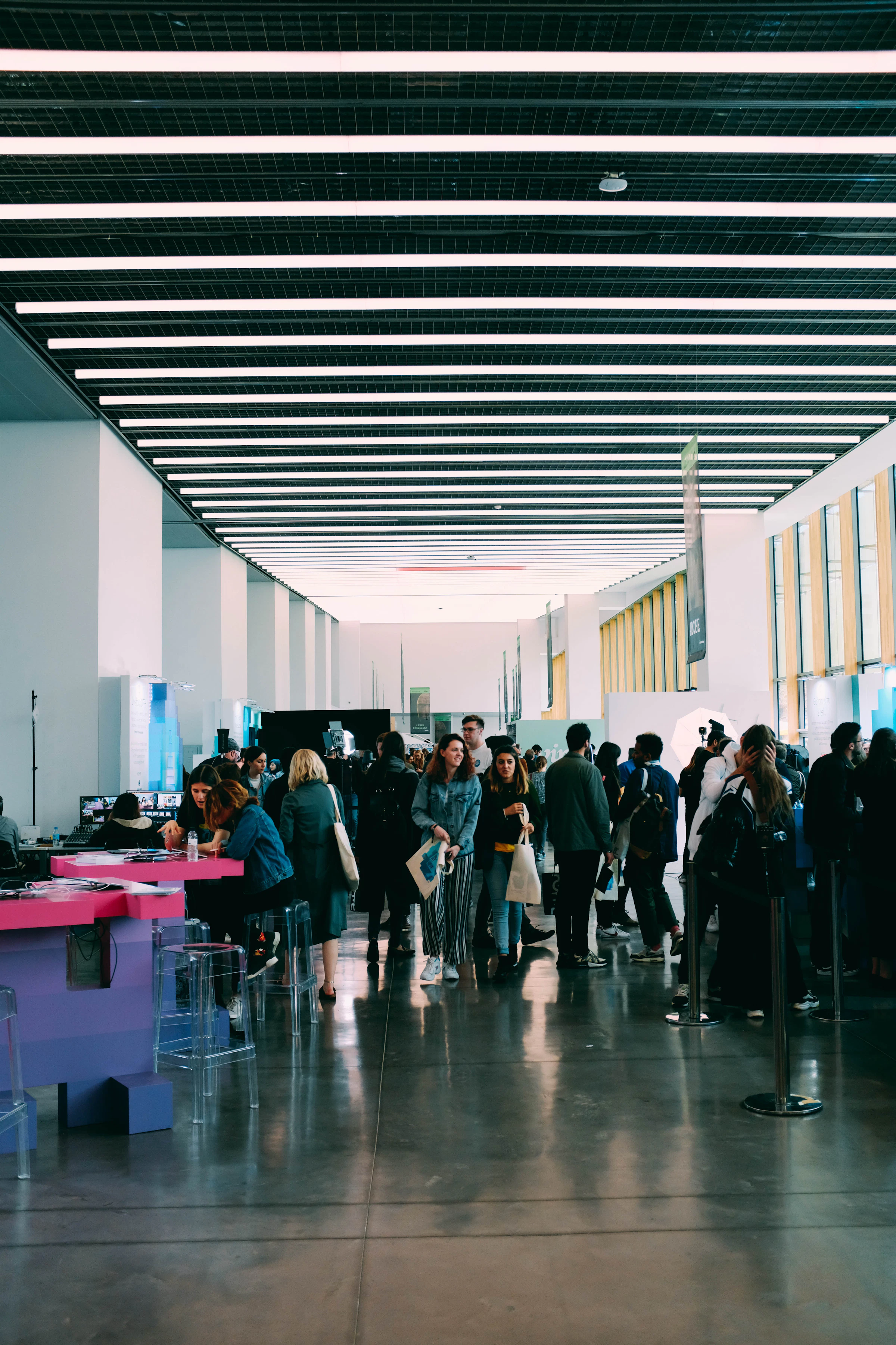Hall d'un salon professionnel avec stands et espaces d'accueil des participants.